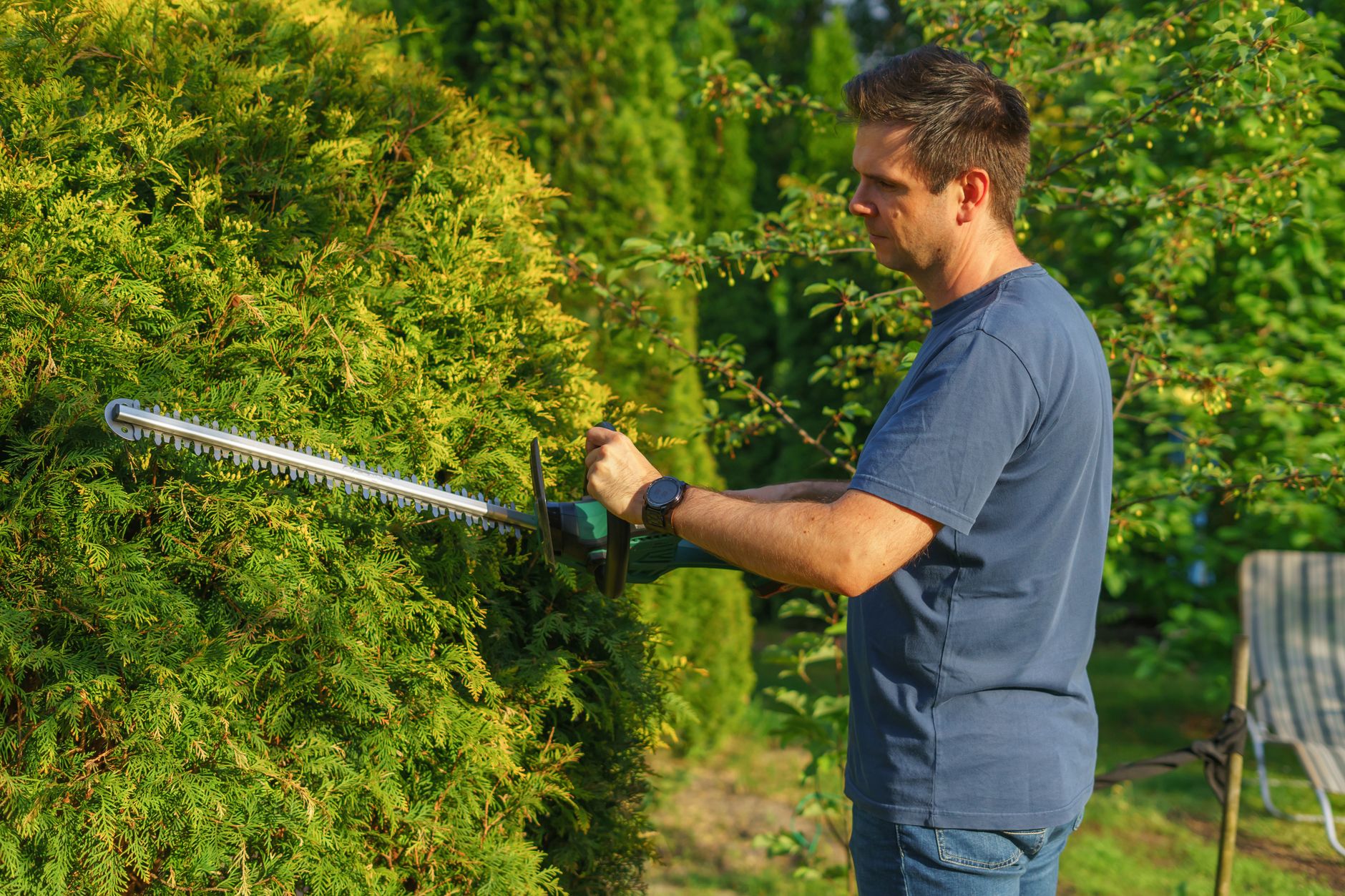 A Prolands crew member trimming a hedge on a Gulf Coast property
